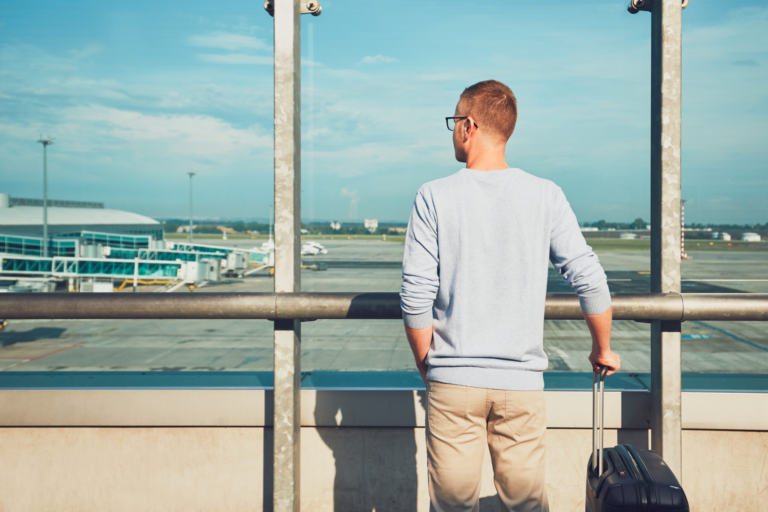 Traveler waiting for departure Man traveling by airplane. Young passenger waiting at the airport for a delayed flight.